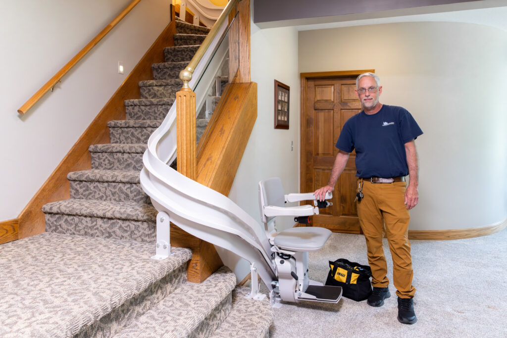 man stands next to stair lift