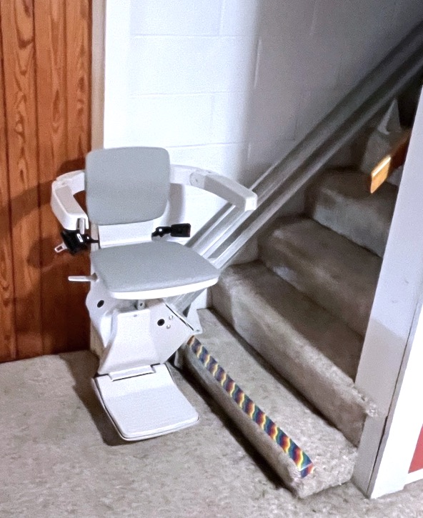 stair lift resting at the bottom of the stairs